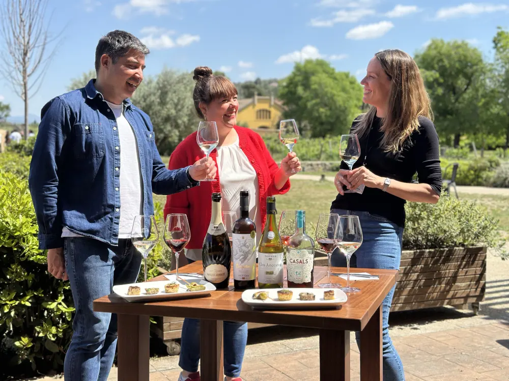 Dues persones visiten un celler al Penedès amb una guia d'enoturisme
